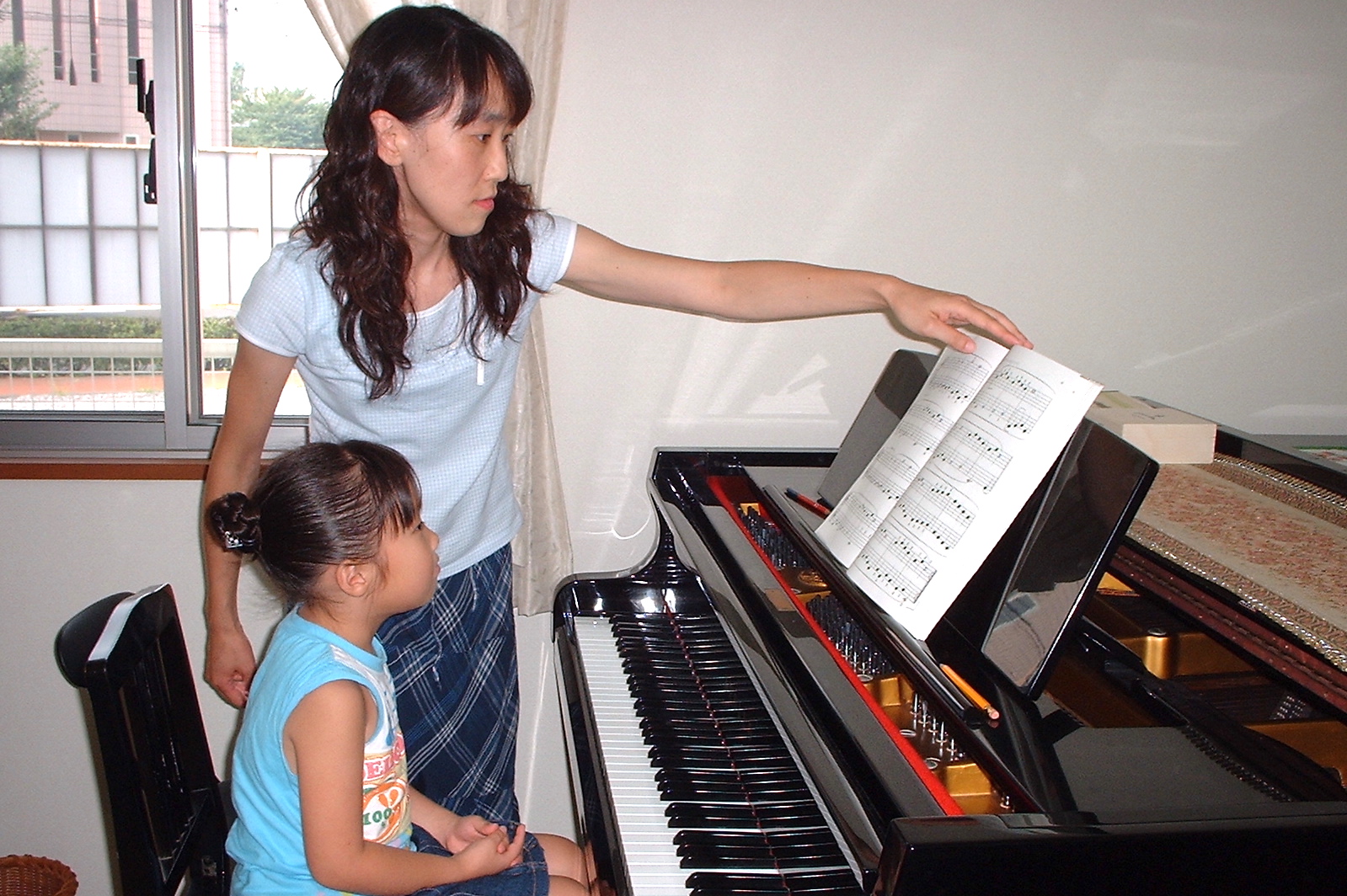 ピアノのレッスンを受ける女児の写真