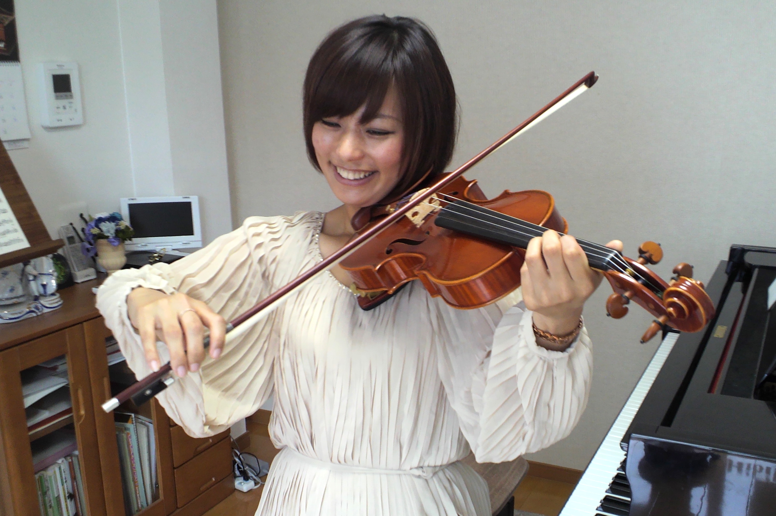 成人女性の生徒さんが楽しそうにヴァイオリンを弾く写真
